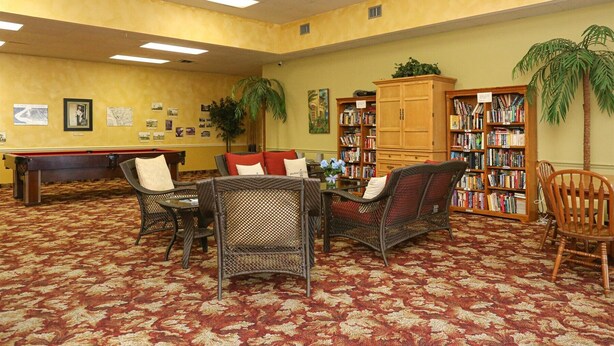 A library with a pool table, wicker chairs, and bookshelves. - Port Charlotte Private Waterfront Condo Wa4410-317 (Port Charlotte)