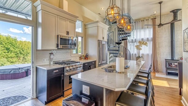 A modern kitchen with a large island, stainless steel appliances, and a view of the outdoors. - The Addition at Villa Santorini (Gary)