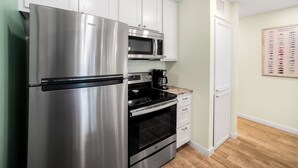 A kitchen with a stainless steel refrigerator, a microwave, an oven, and a coffee maker. - Sunrise Villas 207 - Boardwalk TO THE Beach! (Port Aransas)