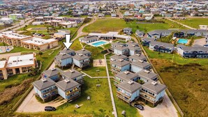 A residential complex with multiple two-story buildings, a central courtyard, and a swimming pool.