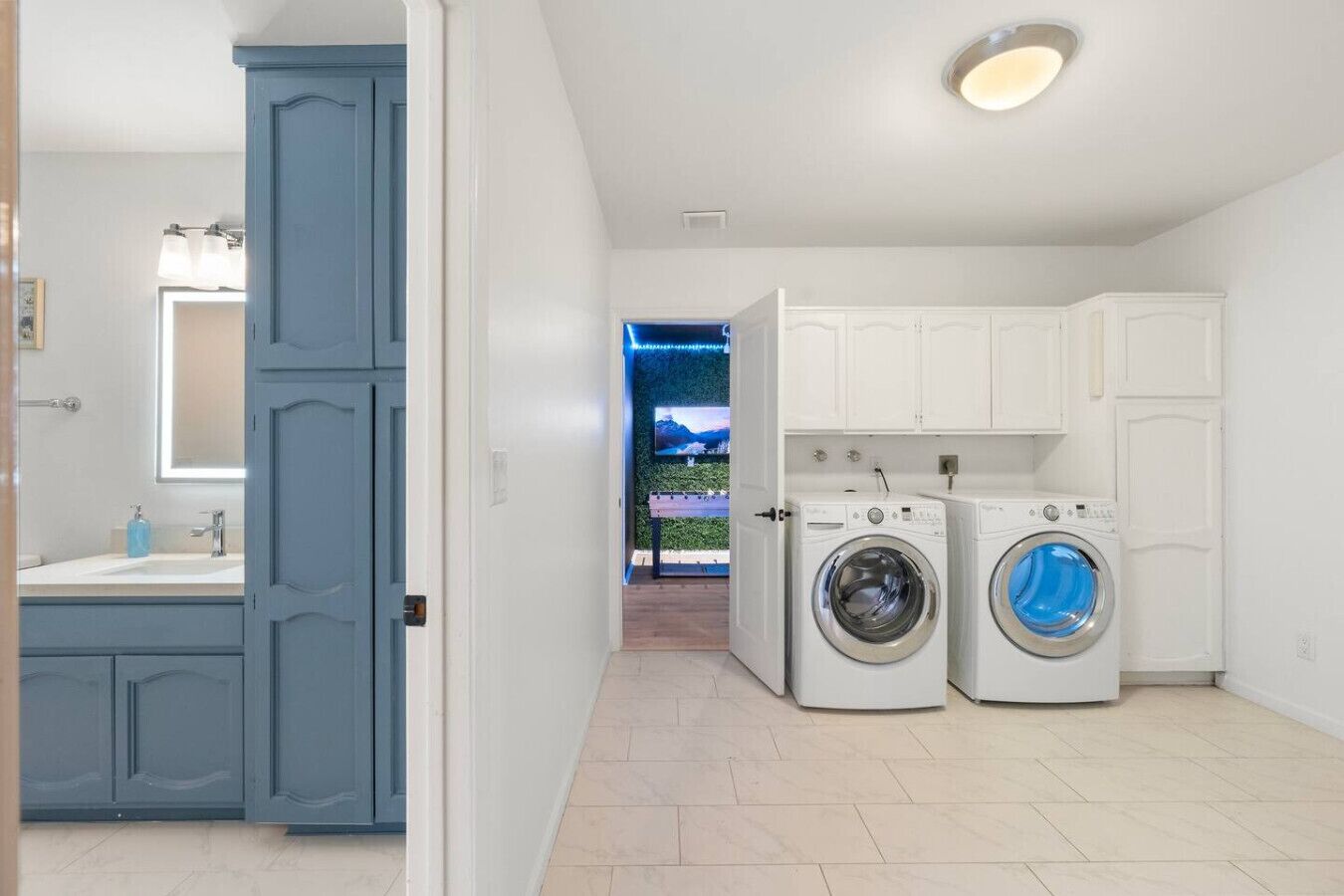 A laundry room with two washing machines and a sink.
