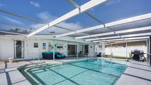 Ein überdachter Pool mit Terrassenbereich, Sitzgelegenheiten und Blick auf die umliegende Landschaft.