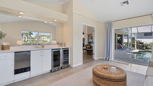 A modern kitchen with built-in appliances, a dining area with a view, and a large sliding glass door to a pool area. - Gic120 (Punta Gorda)