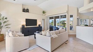 A modern living room with a sofa, TV, and a view of the outdoors. - Gic120 (Punta Gorda)