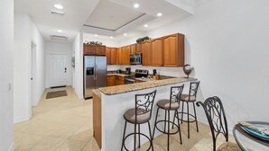 A modern kitchen with wooden cabinets, stainless steel appliances, and a granite countertop. - Ppm3329-112 (Punta Gorda)