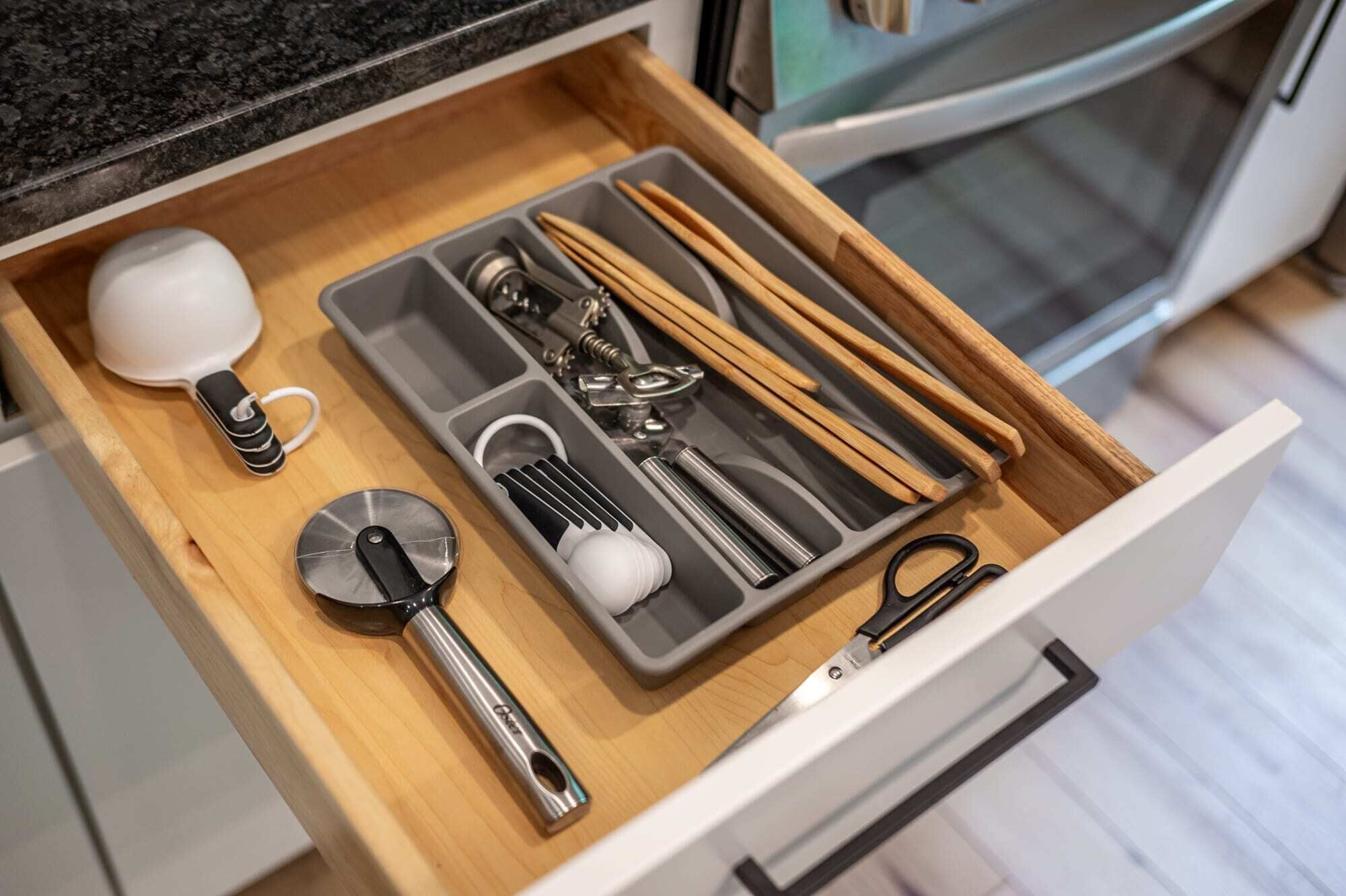 A kitchen drawer with utensils and appliances.