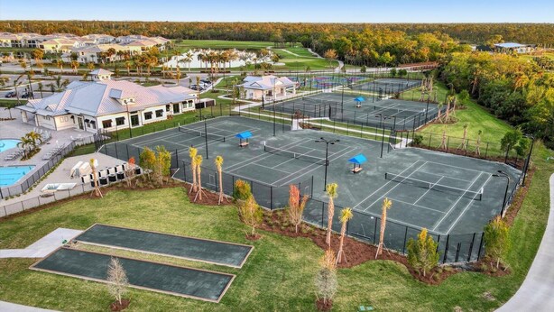 Un vaste espace extérieur comprenant plusieurs courts de tennis, une piscine et un club-house.