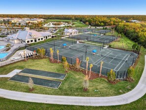 Een groot buitengebied met tennisbanen, een zwembad en een clubhuis.