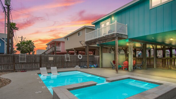A backyard with two swimming pools, a wooden deck, and a building with a balcony. - Boogie Board Bungalow - Pet Friendly! Private Pool! 2 (Port Aransas)