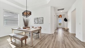 A spacious dining area with a wooden table, bench, and hanging light fixture. - Cbw14724 (Punta Gorda)