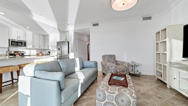 A modern living room with a light blue sofa, patterned armchair, and a small side table. - Hlb14041-613 (Punta Gorda)