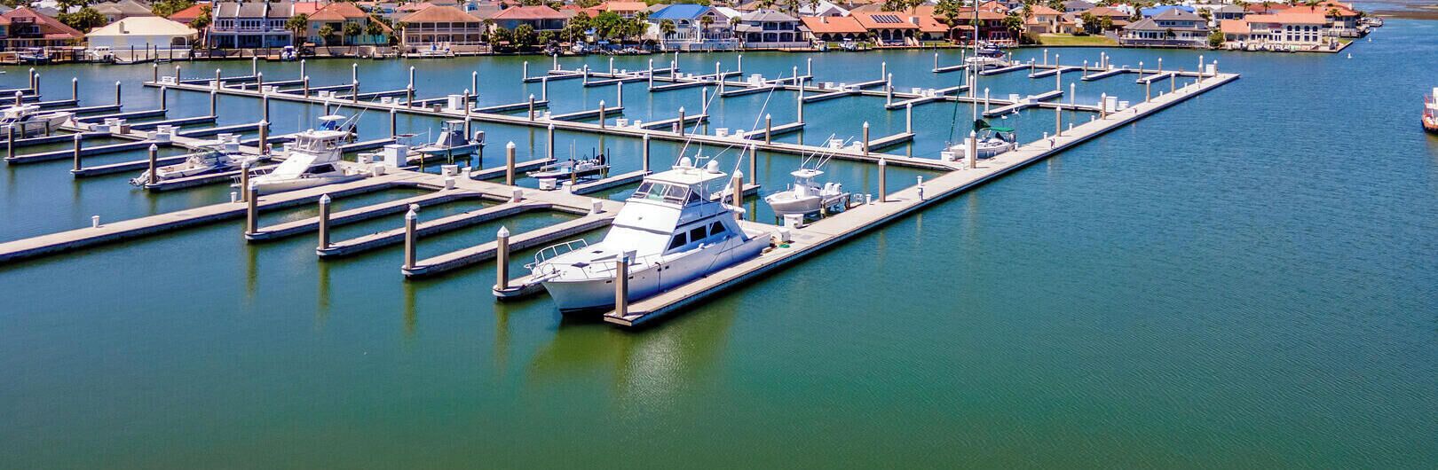 A marina with multiple docks and boats, surrounded by residential buildings.