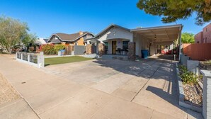 A residential property with a covered driveway, a front yard, and a garage. - Centra Phoenix House Kingbed (Phoenix)