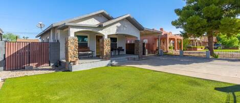 A two-story house with a stone facade, a front porch, and a well-maintained lawn.