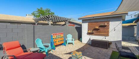 A backyard with a barbecue area, outdoor seating, and a play structure.