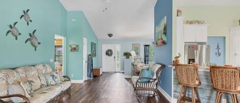 A spacious living room with a sofa, chairs, and a dining area with a table and chairs.