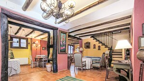 Une pièce spacieuse comprenant un coin repas, un escalier et un lustre.