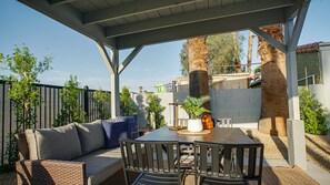 An outdoor patio with a covered seating area, a table, and chairs. - Heatherbrae Phoenix (Phoenix)