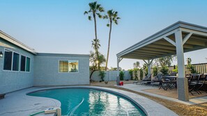 A backyard with a swimming pool, patio furniture, and a covered seating area. - Heatherbrae Phoenix (Phoenix)