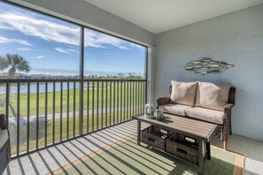 Un balcón con vista a un campo de golf y una masa de agua.