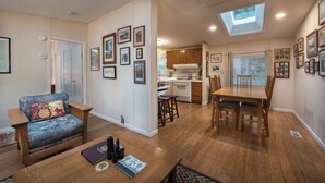 Un grand espace de vie comprenant un canapé, une table à manger et une cuisine à l’arrière-plan.