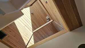 Un plafond en pente, avec des panneaux en bois et une structure en poutres métalliques.