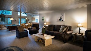 A spacious living room with a pool table, leather sofas, and a wooden ceiling. - The Last Resort (Yosemite National Park)