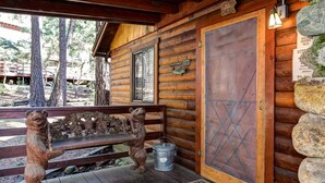 A wooden cabin with a bench, a metal bucket, and a door with a metal grid. - Mia Mora (Yosemite National Park)