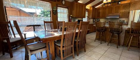 Una cocina de madera con una mesa de comedor y sillas, un reloj y un cartel que dice "Live, Love, Laugh & Be Thankful".