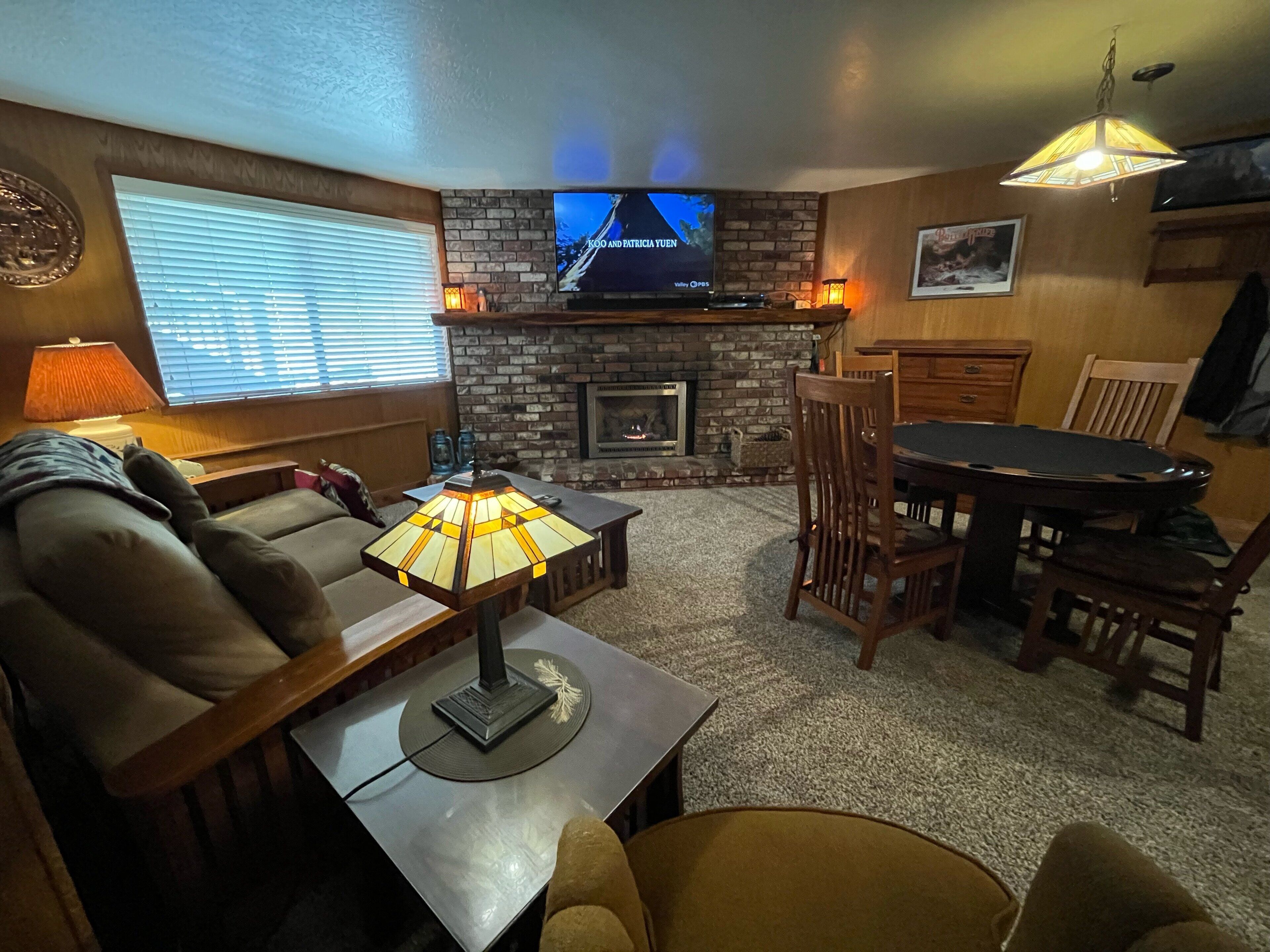 Uma sala de estar acolhedora com lareira, televisão e espaço para refeições.