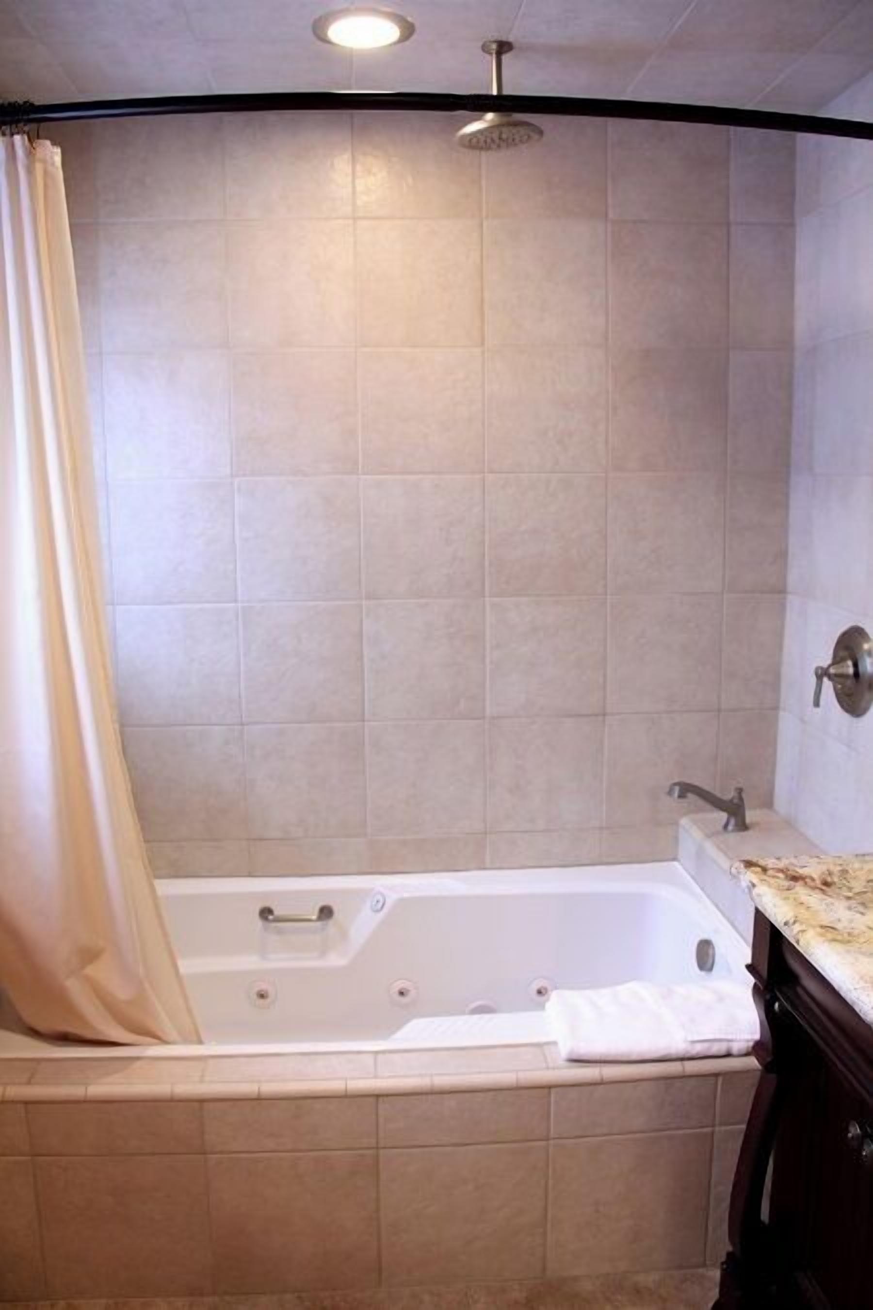 Un baño con bañera, ducha y tocador con encimera.