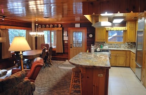 A wooden cabin interior with a dining area, kitchen, and bar seating. - Half Dome (Yosemite National Park)