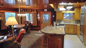 A cozy cabin interior with a dining area, kitchen, and bar seating. - Half Dome (Yosemite National Park)
