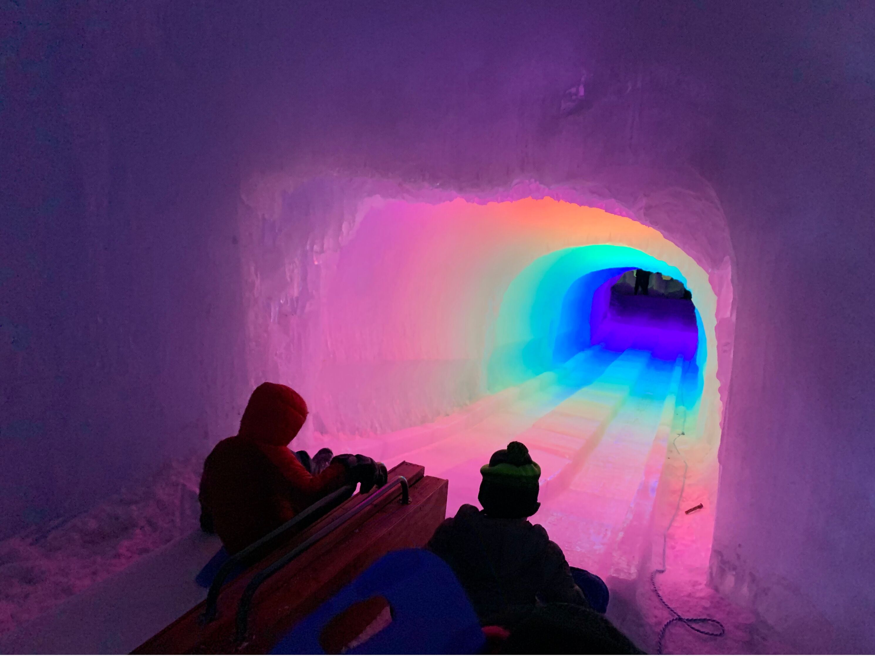 Un túnel de hielo con iluminación colorida.