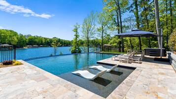 A swimming pool with lounge chairs and a pergola.