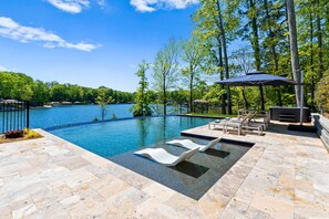A swimming pool with lounge chairs and a pergola. - Fox Run LKN (Denver)