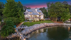 A large, two-story house with a landscaped garden and a pond. - Sterling on Strawpocket (Mooresville)