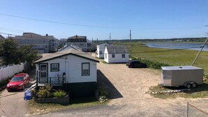 A residential area with houses, a red car, a trailer, and a clear sky. - Seascapes - W153 (Wells)