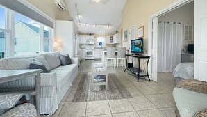 A spacious living area with a sofa, dining table, and kitchen in the background. - Seascapes - W153 (Wells)