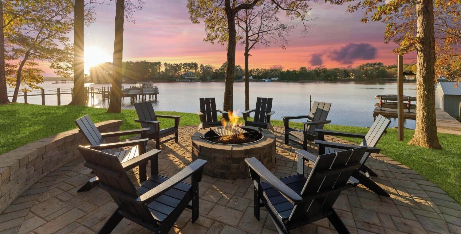 A lakeside patio with 14 beds and 18 sleeps, surrounded by trees and a fire pit.