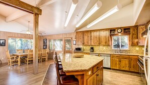 A spacious kitchen with wooden cabinets, a granite countertop, and modern appliances. - Yosemite's Riverfront Retreat (Yosemite National Park)
