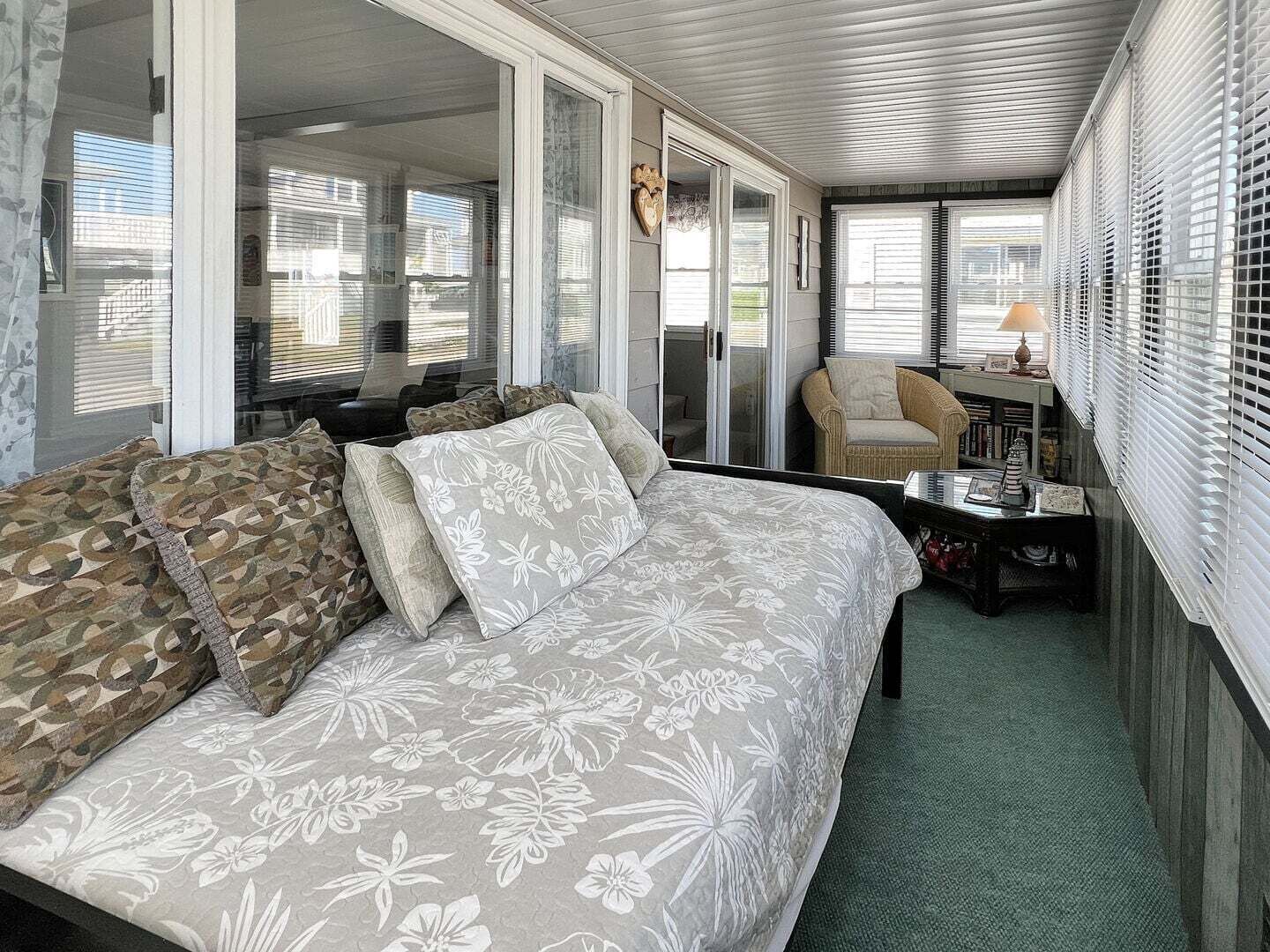 Een kamer met een bank, een stoel, een klein tafeltje en een lamp.