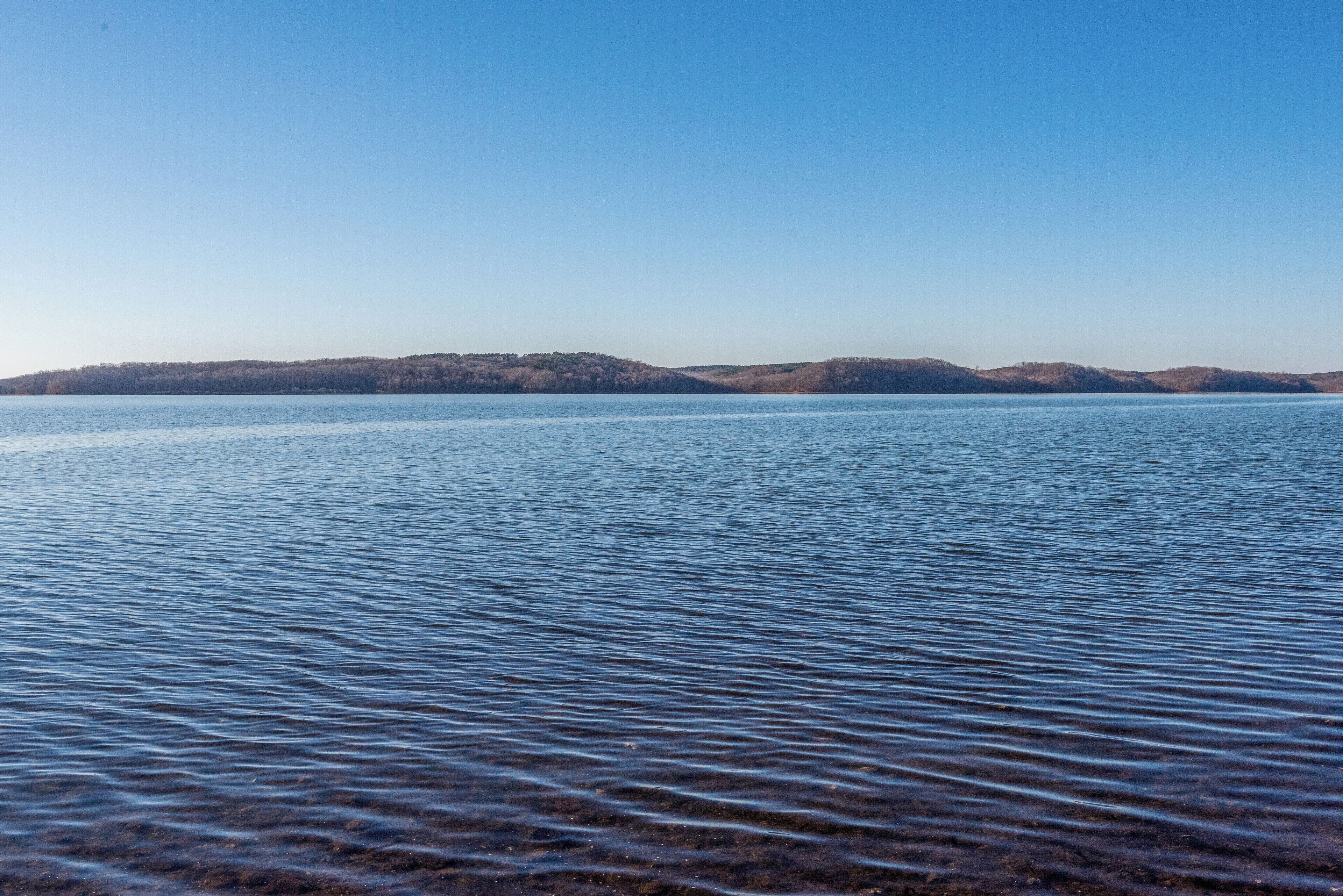 A calm lake with a distant shoreline.