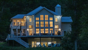 A two-story house with a balcony, a staircase, and outdoor seating. - Eagle Roost Chalet- Modern Kentucky Lake Chalet (Waverly)