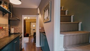 A kitchen with dark blue cabinets, a wooden countertop, and a hanging light fixture. - Rasen Stay Cottage - Cosy Vintage  Retreat in Lincoln (Lincoln)