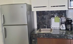 A kitchen with a refrigerator, a sink, a blender, and a coffee maker. - Upscale Loft with private terrace near the Mall Restaurants & Tajamar Waterfront (Cancun)