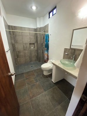 Un baño con ducha, inodoro y lavamanos.