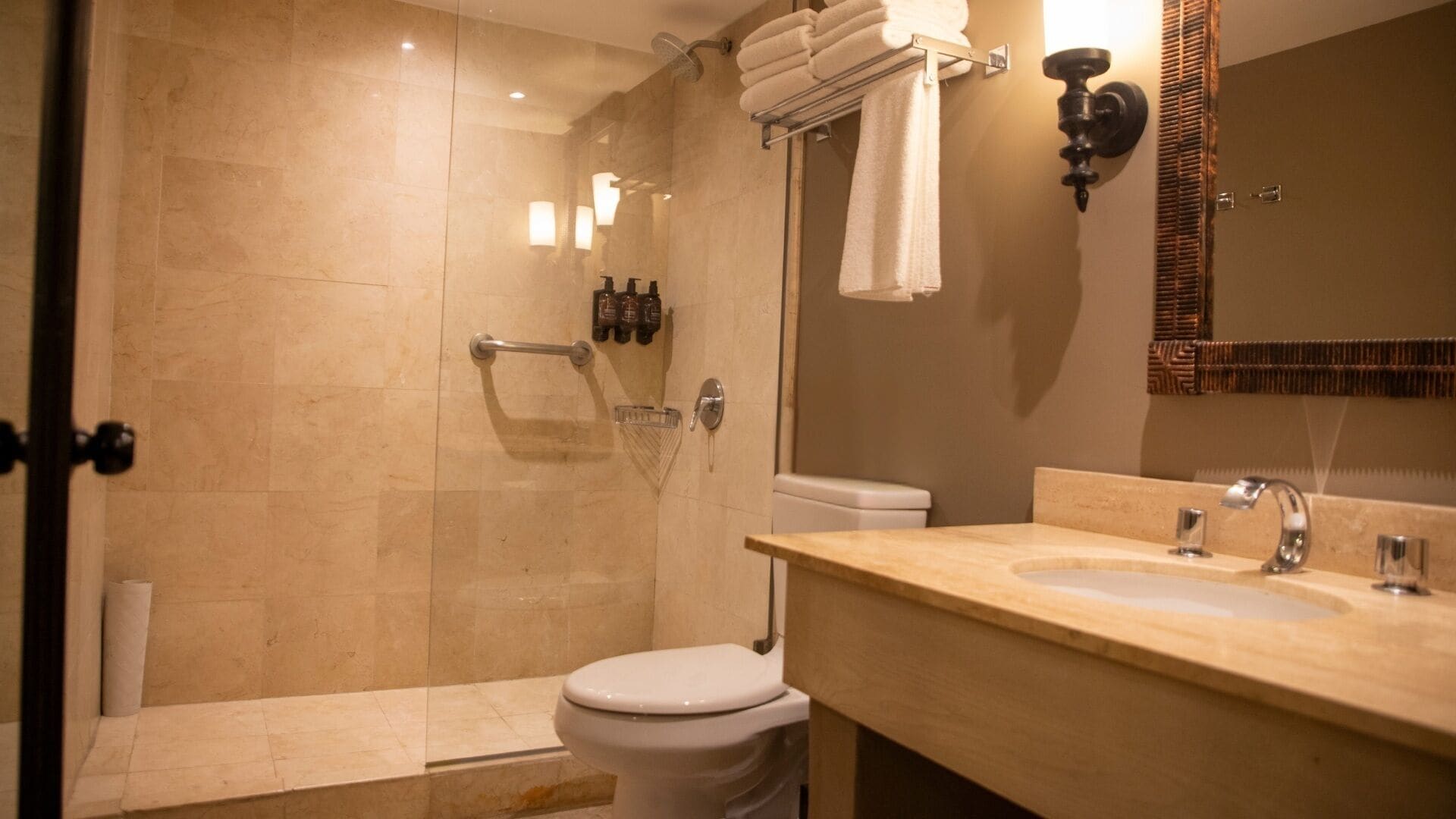 Een moderne badkamer met douche, toilet en wastafel.