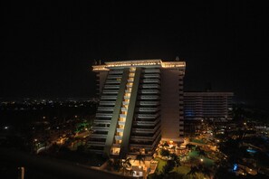 A multi-story hotel with balconies and a pool area.
