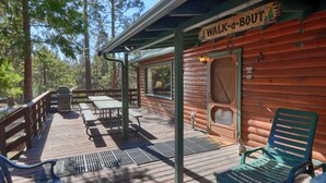 A wooden cabin with a deck, outdoor seating, and a sign reading "Walk-a-Bout". - Walk-a-bout (Yosemite National Park)